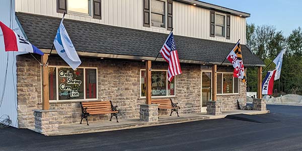 Front view of 410 Seafood. A stone faced building with American flags hanging.